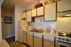 Galley kitchen with ceramic tile floor and open pass through to dining area