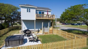 View of fenced in yard and hot tub/patio area. 