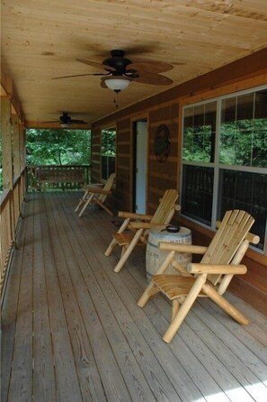 The covered porch has inviting chairs and a porch swing!