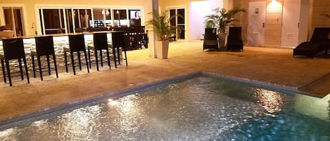 Pool, beautiful lit bar and outside patio with outside television