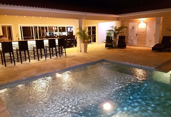 Pool, beautiful lit bar and outside patio with outside television