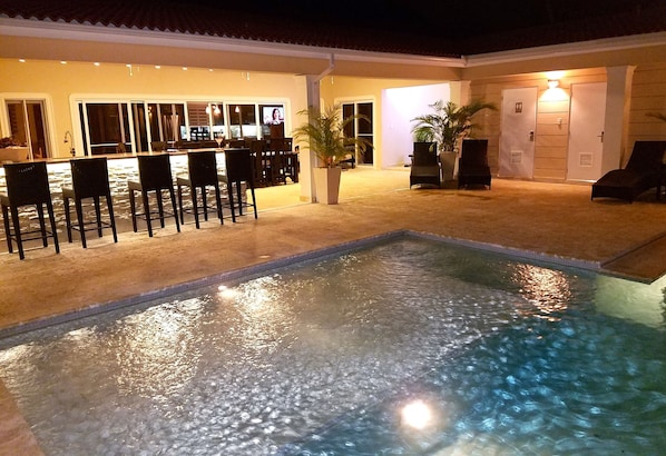 Pool, beautiful lit bar and outside patio with outside television