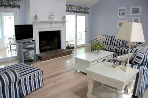 The great room has high ceilings, a fireplace and opens ot a sun room.