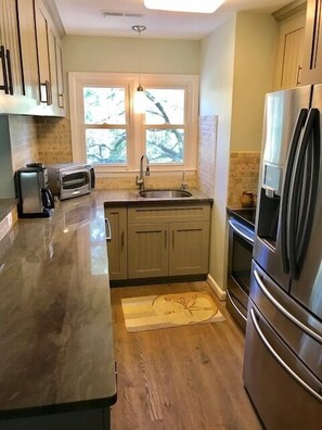 The galley kitchen features granite counter tops and stainless steel appliances.