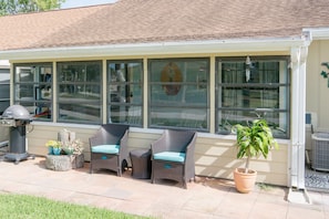 Enclosed back porch and outdoor grill.