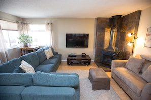 Living area features comfortable sectional couch, 52" TV, and a sofa loveseat