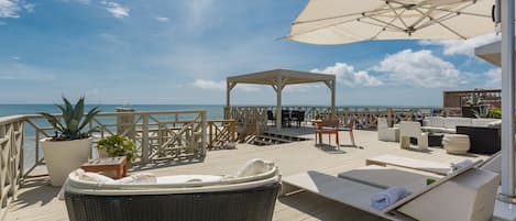 Deck of this New Smyrna beach cottage rental with ample seating and shade.