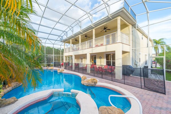 Pool area with plenty of seating and a safety fence.