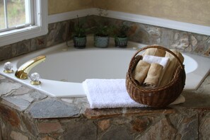 Jetted jacuzzi tub for two with view out the window. 
Bath salts await you