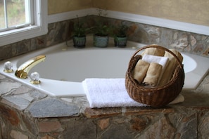 Jetted jacuzzi tub for two with view out the window.
Bath salts await you