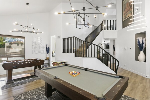 Front room with pool table, foosball table and seating