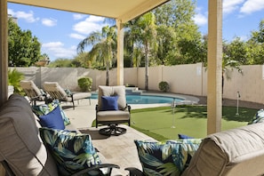 Beautiful backyard with pool, pool loungers, seating area, putting green, hot tub