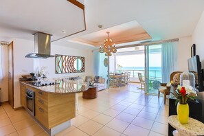 Living room view which includes Smart Tv, Full kitchen, great view to the beach and pools!