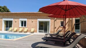 Bains de soleil et transats au bord de la piscine