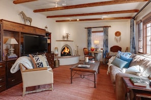 Living room with queen size sofa bed, fireplace, and smart tv.
