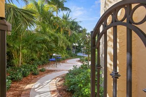 Custom iron gate opens to the brick pathway leading to large back yard and pool!