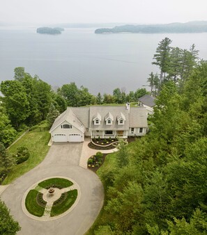 Drone photo of the property, fountain, two car garage, on the lake: Lake views