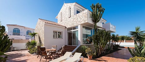 House exterior with solarium and garden leading to the pool