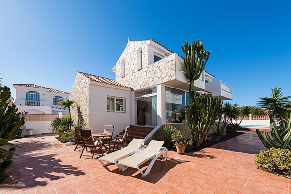 House exterior with solarium and garden leading to the pool