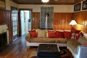 Super cozy livng room entirely covered in wood. Knotty Pine Paneling, oak hardwood floors and wood ceilings.