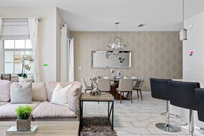 Living room with access to the dining room and kitchen and view to the pool area