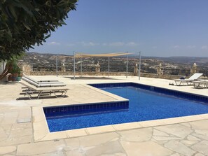 Poolside with shade sails and a hint of the wonderful view