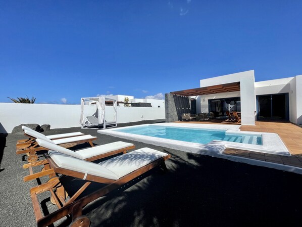 Large terrace with outdoor furniture and private pool heated by a heat pump
