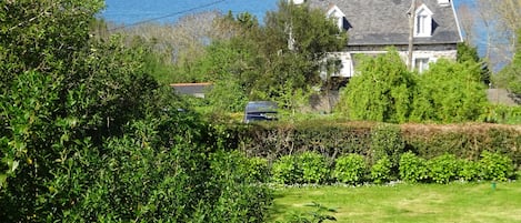 Vue sur le jardin et la mer depuis la fenêtre de la chambre des"Mouettes"