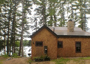 Back of cabin w/new shingles, roof and stone chimney
