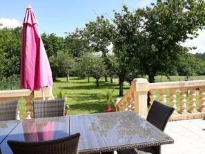 Terrasse extérieure avec salon de jardin & barbecue et accès au verger