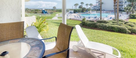 Patio - Pool view patio features a table with seating for four and an electric grill for outdoor barbequing. Perfect spot to relax and unwind!