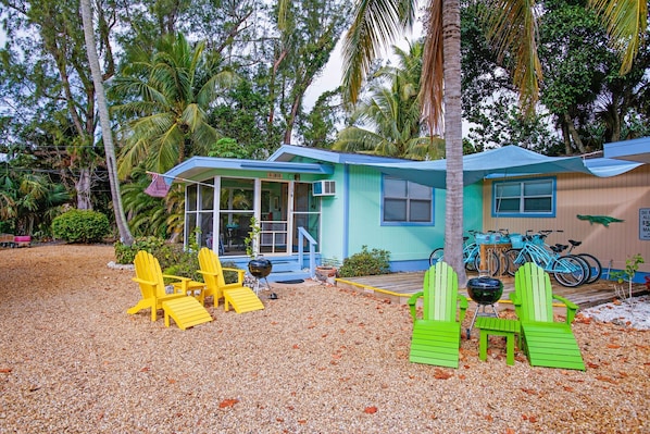 The Ibis cottage exterior featuring adirondack chairs, barbecue and private lanai.