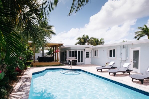 Beautiful heated pool with large grill and covered patio area