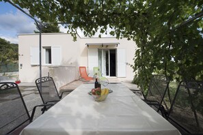 Outdoor dining in natural wine tree shade by the pool