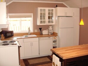 Kitchen w microwave, stove, fridge, toaster, dishwasher and plenty of pots/pans 