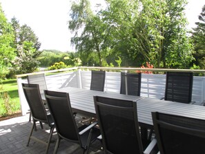 Terrasse mit großen tischen, gemütlichen Stühlen, Grill