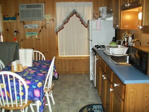 View of the kitchen area with stove,refrigerator, microwave.