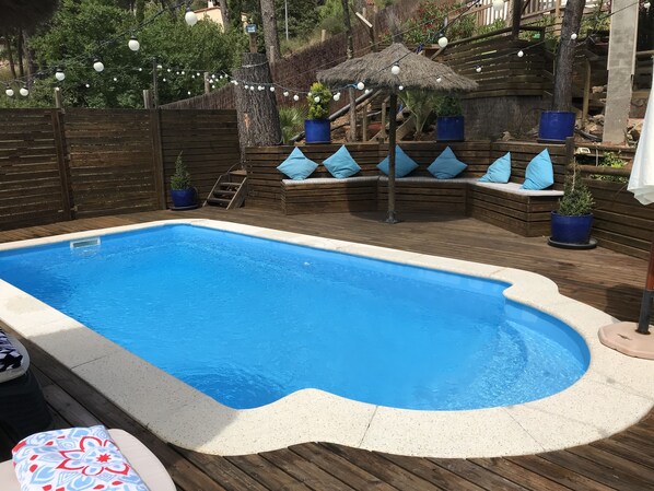 Decked pool area with sun loungers and seating. 