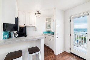 Partial ocean view kitchen off living room with breakfast bar