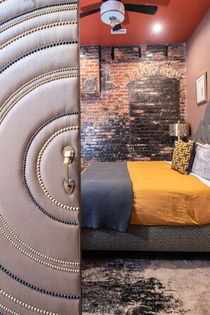 Rest easy on the king-sized bed, adorned with plush linens and surrounded by exposed brick charm.