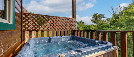 Enjoy a private hot tub on the deck, offering relaxation with scenic views.