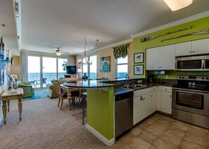 Living area with breakfast bar, dining table and sleeper sofa and bucket chairs