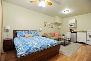 Open floor plan with queen bed, couch, and large 42 inch flat screen tv.