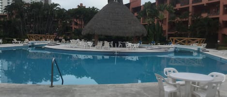 Pool with big palapa island, granite bar and sink. lounge chairs tables & chairs