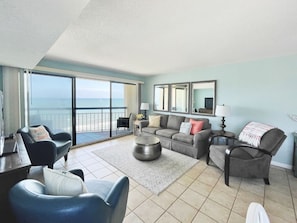 Sleeper sofa, TV, leather chairs, recliner, and oceanfront balcony.