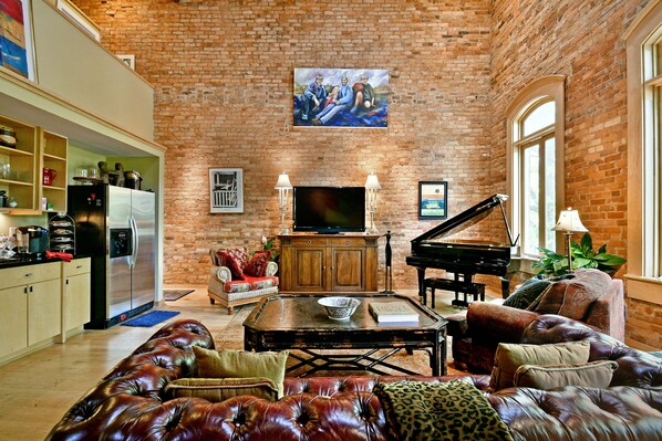Spacious gathering room with Baby Grand, and TV over looking Main Street.