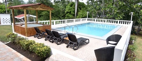 Swimming pool with Jacuzzi also pool furniture with BBQ pit roof to the left