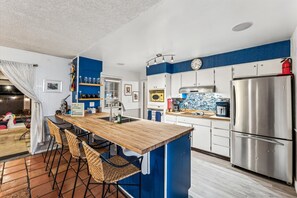 Open concept kitchen is ready for cooking with toaster, pancake griddle, blender, and more!