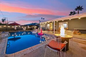 Relax poolside with a cozy fire pit and plenty of shade under the umbrella. Perfect for day or night