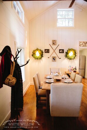 Dining room with vaulted ceilings, shiplap walls, and farm table.